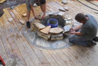 Craftsmen Constructing A Natural Stone Fire Pit On Wooden Deck With throughout sizing 4000 X 3000