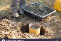 Hispanic Carpenter Mixing Cement For Deck Footing Stock Photo intended for size 1300 X 956