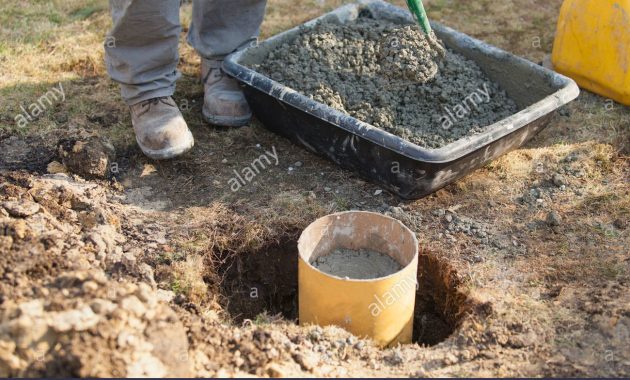 Hispanic Carpenter Mixing Cement For Deck Footing Stock Photo intended for size 1300 X 956