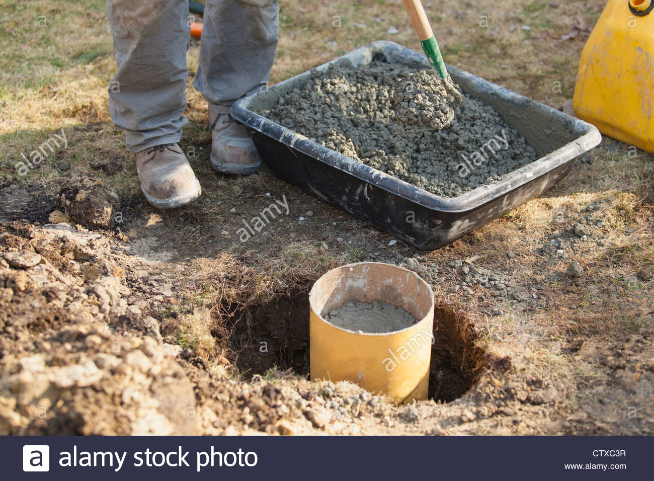 Hispanic Carpenter Mixing Cement For Deck Footing Stock Photo intended for size 1300 X 956